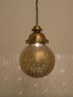 Handcrafted Moroccan ball suspension lamp with a sparkling orb and brass domes.